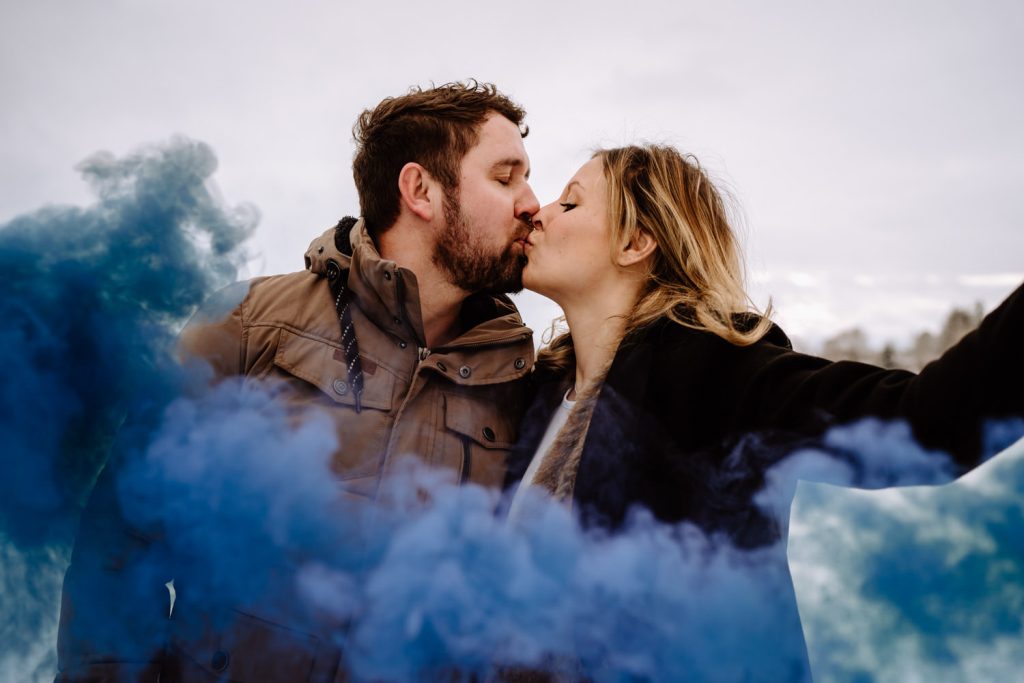 Gender Reveal mit Rauchbombe - Paar steht im Nebel
