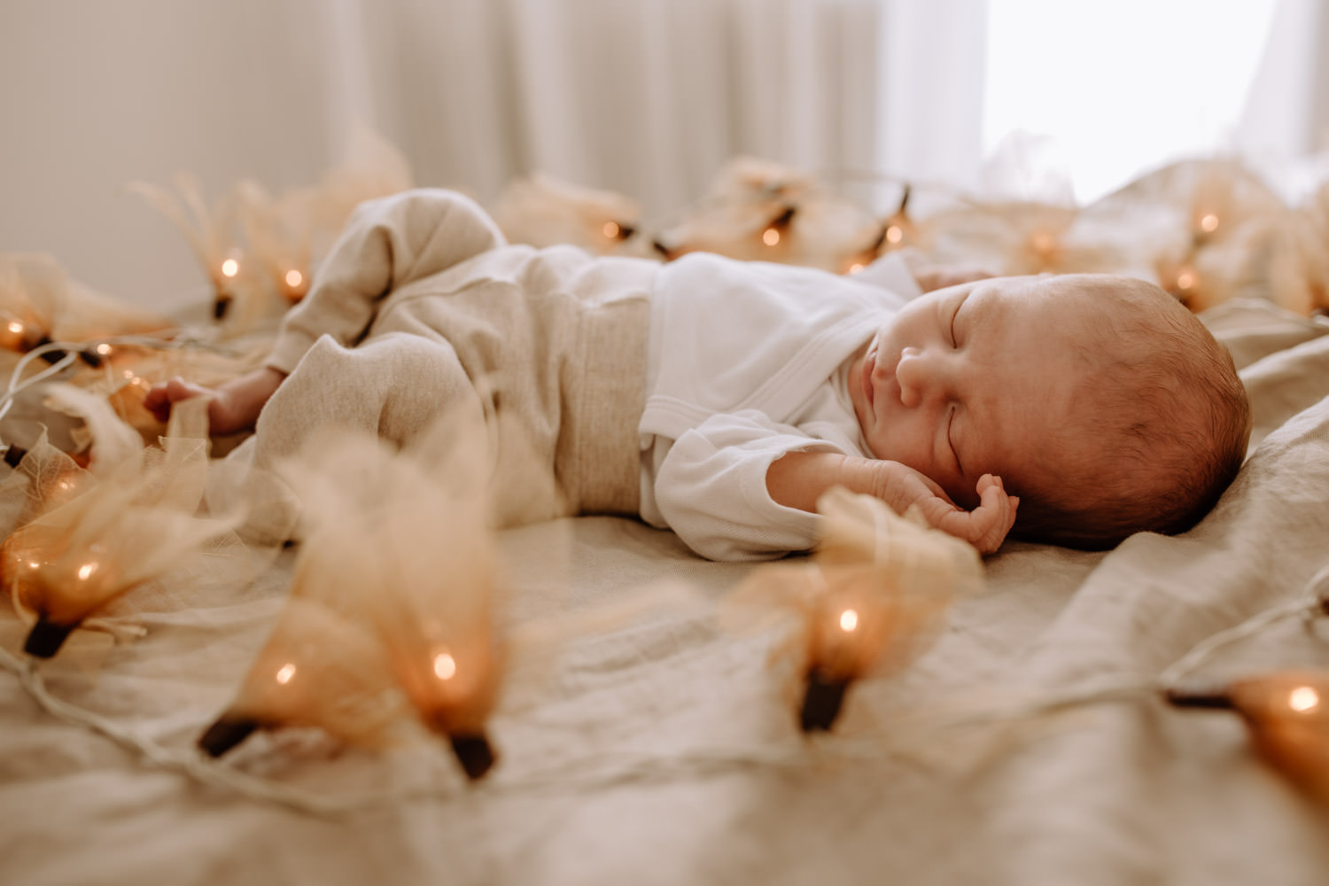 Süße Babyfotos zu Hause in Schongau - Baby schläft - Lichterkette als Deko
